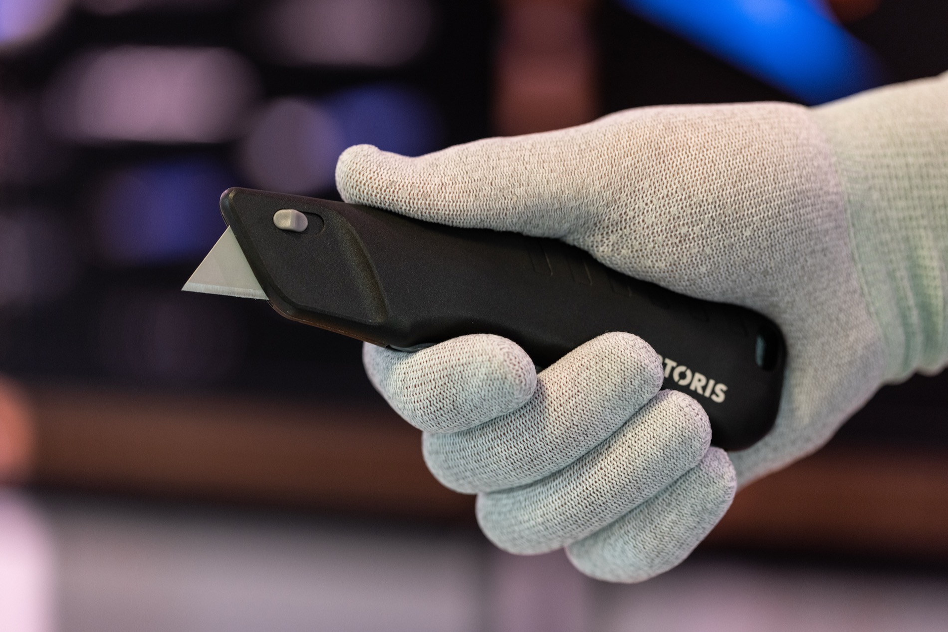 TORTORIS safety knife held in a gloved hand