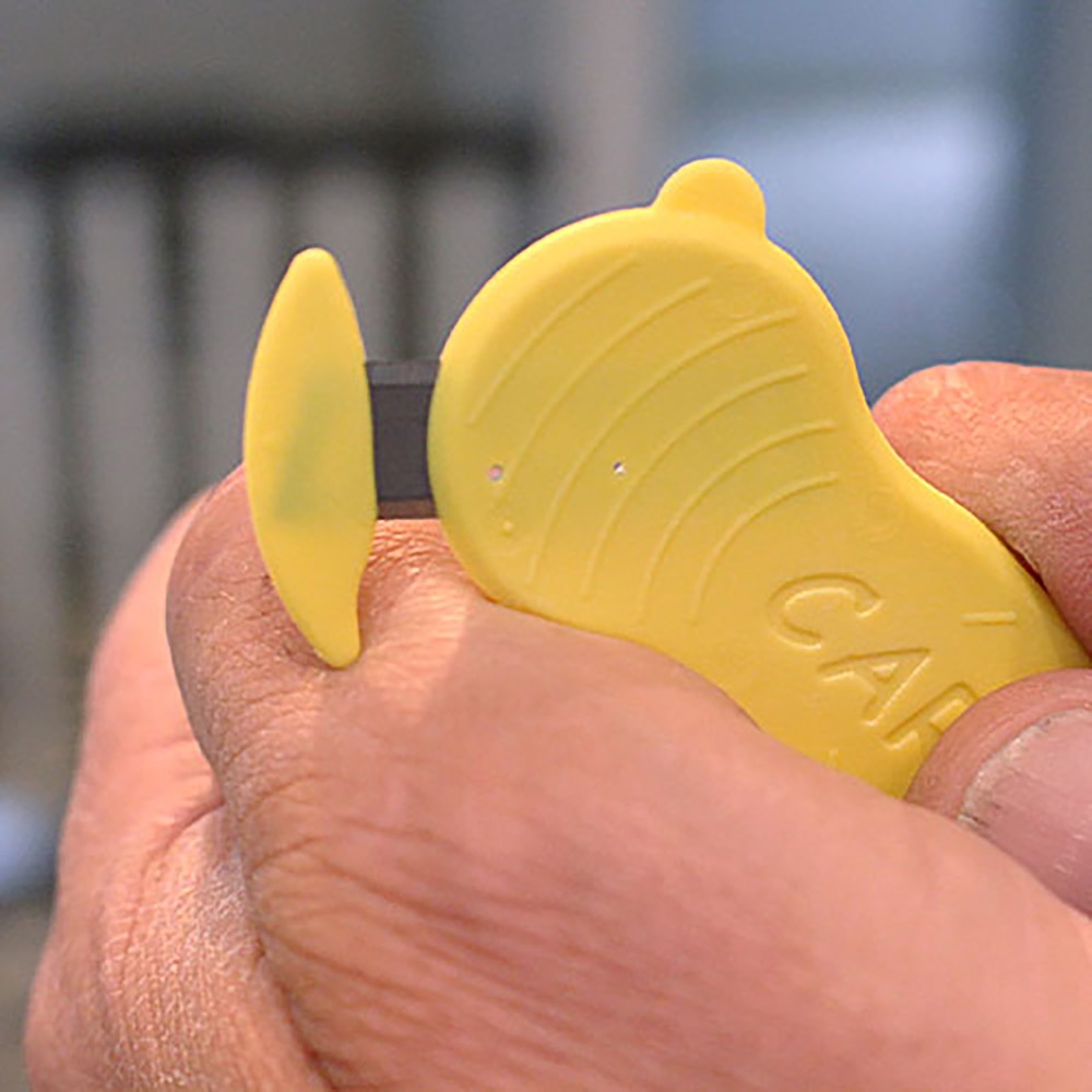 In-use photo: hand holding a yellow custom-coloured ULTRA SAFE 48 with an embossed customer logo